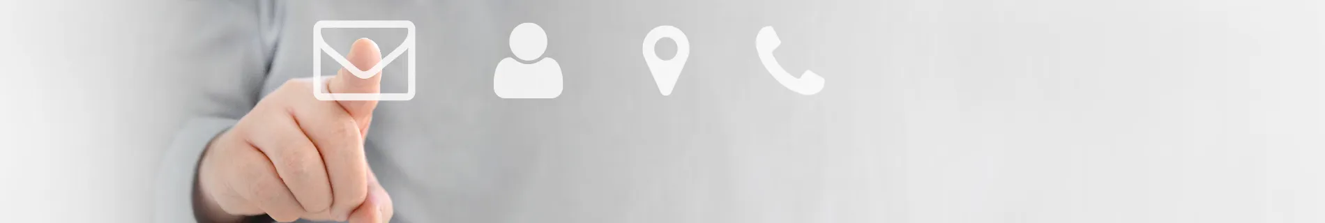 Ruka ukazující na ikony e-mailu, kontaktu, adresy a telefonu